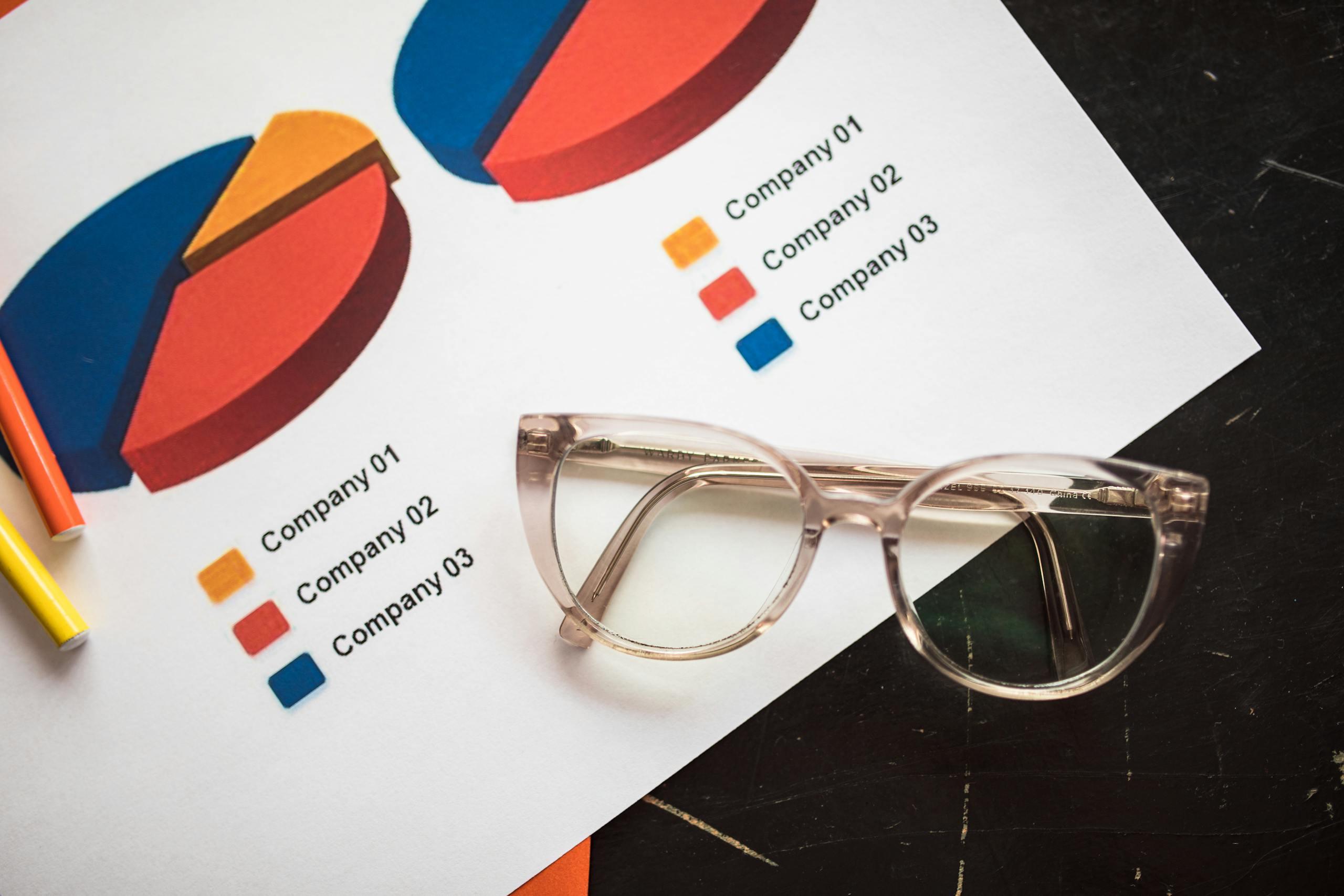 Photo of business charts and eyeglasses on a desk, ideal for finance and analytics themes.